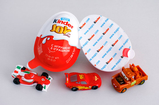Tambov, Russian Federation - June 01, 2017 Kinder Joy eggs with three Kinder &ETH;&iexcl;ars toys on gray background. Kinder Joy manufactured by Italian company Ferrero. Studio shot.