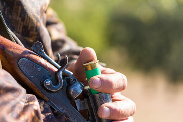 Hunting period, autumn season open. A hunter with a gun in his hands in hunting clothes in the...