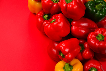 Fresh red, yelow, green bell pepper on a red background.