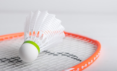 A badminton shuttle on a racket on a white background