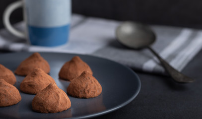 chocolate truffles on a plate with a cup of coffee