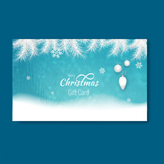 Merry Christmas gift card design with snowflakes and hanging bauble on blue winter landscape background.