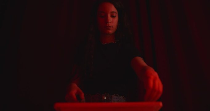 young woman develops a sheet of photographic paper in the dark room