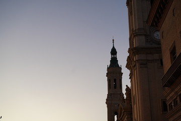 Fototapeta na wymiar Atardecer con torre de iglesia de fondo