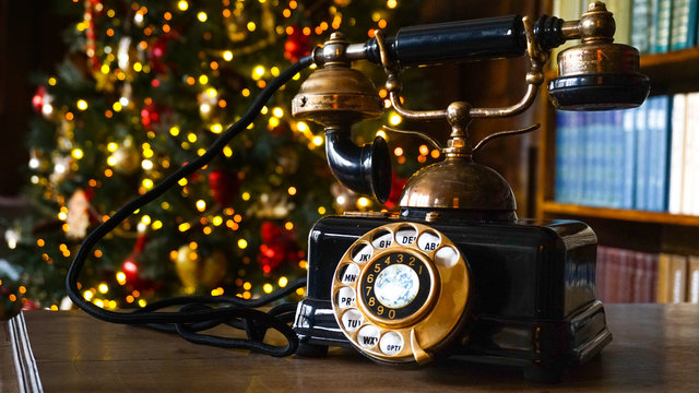 Retro phone close up and Christmas tree in the background