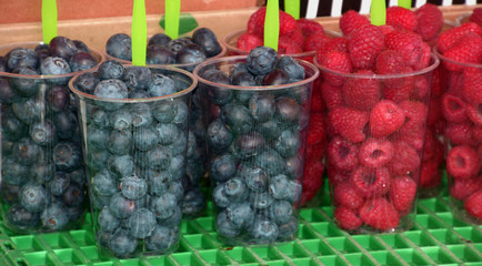 Ready-to-eat fruit salad made of blueberries and raspberries in plastic container at street market, fresh fruit in plastic cups