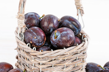 Wicker basket with ripe plums.