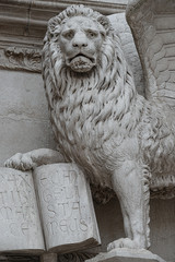 Winged lion with a Bible and a priest at Basilica San Marco in Venice, Italy, summer time, details, closeup