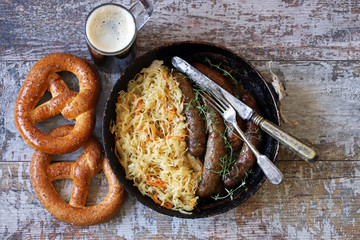 Oktoberfest food. Hot Bavarian sausages with sauerkraut in a pan. Delicious beer festival food