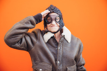 Funny portraits with old grandmother. Senior woman acting as an aviator from the first world war