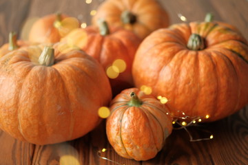 pumpkins with a shining garland on a wooden table