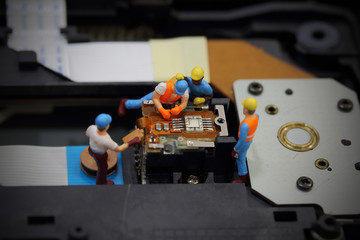 Selective focus of miniature engineer and worker to fixed and repair cd rom of mainboard computer and use for business background.