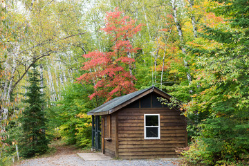 Wooden cottage in forest in early autumn. Ontario. Canada