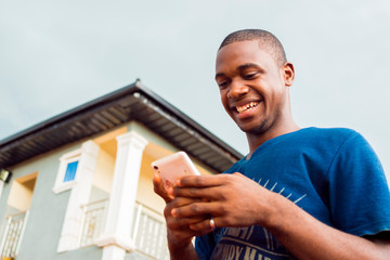 Fototapeta premium young black African man excited chatting with friends on social media. man watching videos online