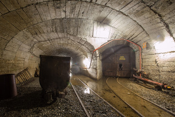Fototapeta na wymiar Gold mine ore shaft tunnel with wagon minecart