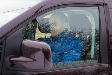man driving  winter,behind the car window a man sits, in the window a car man driving