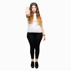 Fototapeta premium Young beautiful woman wearing casual white t-shirt doing stop sing with palm of the hand. Warning expression with negative and serious gesture on the face.