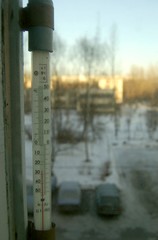 old mercury outdoor street thermometer with celsius on the window at winter in the city