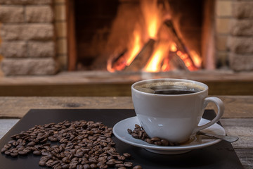 Cozy fireplace and a cup of coffee, coffee beans, in country house, winter vacation.
