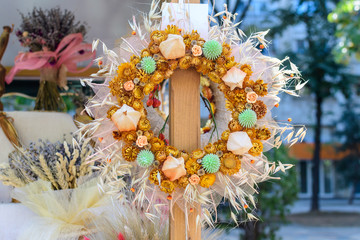 Pastel dried flowers wreath with yellow summer flowers, displayed for sale at an weekend deco fair, selective focus