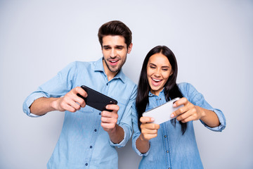 Photo of charming cute nice fascinating beautiful couple of two trendy people playing with each other some games in gamepad isolated white grey color background