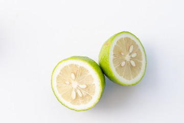 halves of fresh green lime with sheets on a light background