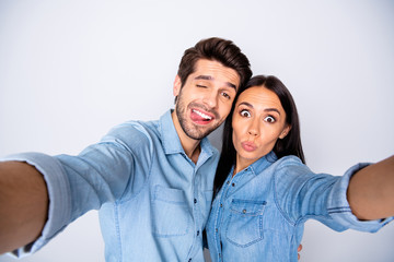 Self-portrait of his he her she nice attractive lovely cheerful cheery winsome couple grimacing fooling joking isolated over light white gray pastel color background