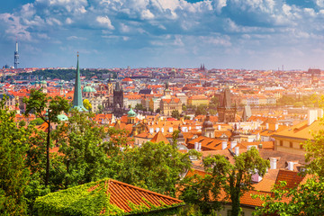 Fototapeta na wymiar Prague red roofs and dozen spires of historical Old Town of Prague. Cityscape of Prague on a sunny day. Red rooftops, spires and the Charles Bridge and Vltava River in the background. Prague, Czechia.