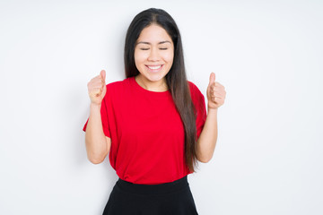 Beautiful brunette woman wearing red t-shirt over isolated background excited for success with arms raised celebrating victory smiling. Winner concept.