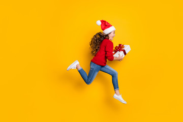 Full length profile photo of amazed small lady jumping high taking giftbox from santa in x-mas...