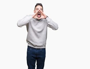 Young handsome man wearing sweatshirt over isolated background Shouting angry out loud with hands over mouth