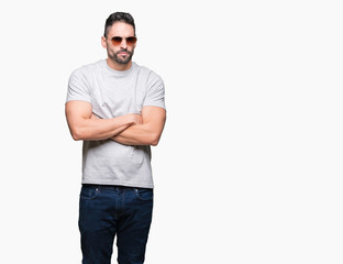 Young handsome man wearing sunglasses over isolated background skeptic and nervous, disapproving expression on face with crossed arms. Negative person.