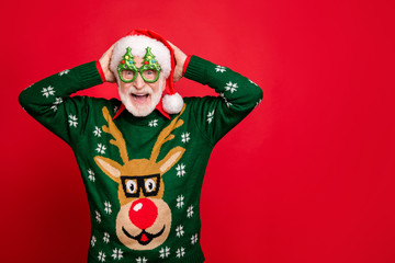 Photo of funny grey haired santa overjoyed with children and relatives coming to newyear party wear specs x-mas tree shape ugly ornament reindeer sweater isolated red background - obrazy, fototapety, plakaty