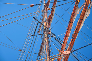 Mast of an old sailing naval ship under a bright blue sky
