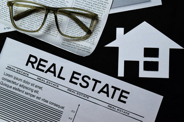 Real Estate text in headline isolated on black background. Newspaper concept