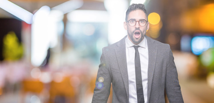 Young handsome business man over isolated background afraid and shocked with surprise expression, fear and excited face.
