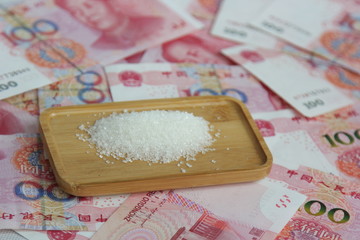 sugar on a wood plate on money background
