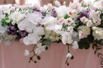 Lots of luxurious fresh flowers on the groom and bride 's wedding table