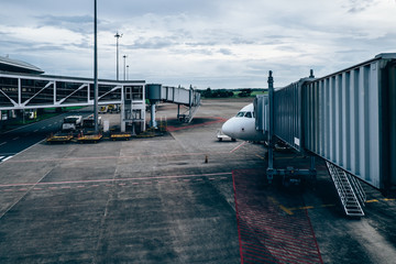 Passenger boarding bridge attached to the airplane door in one of the terminal gates in the...