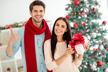 Portrait of two people romantic spouses hold hift showing sign thumb up enjoy christmas time x-mas holidays in house indoors