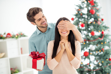 Portrait of two people romantic woman wait for christmas package giving by her husband enjoy noel x-mas tradition in house indoors