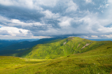 Fototapeta na wymiar Green Mountain and Stormy Sky Landscape