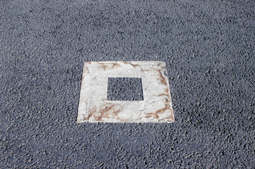White square shape marking on asphalt road