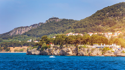 Fototapeta premium Sailboat in the sea in the evening sunlight with mountains background, luxury summer adventure, active vacation in Mediterranean sea, Croatia. Sailing ship luxury yacht with white sails in the Sea.