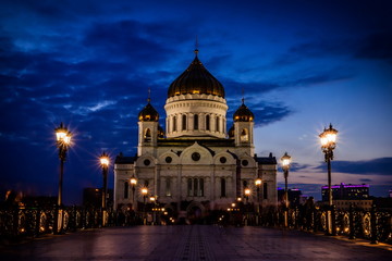 Fototapeta na wymiar Illuminated Cathedral of Christ the Savior framed with old style street lights of Patriarchy Bridge at night.