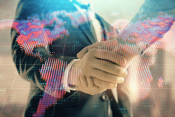 Double exposure of world map on cityscape background with two businessmen handshake. Concept of international business