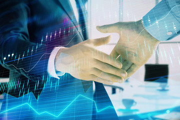 Multi exposure of financial graph on office background with two businessmen handshake. Concept of success in business