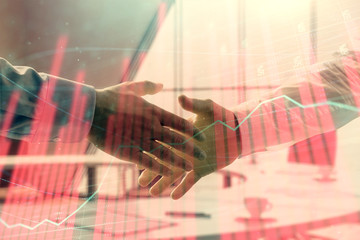 Multi exposure of financial graph on office background with two businessmen handshake. Concept of success in business