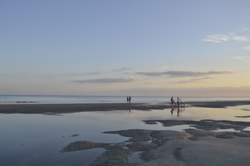 Hilton Head Island, sunset on the beach background people doing sports. - obrazy, fototapety, plakaty