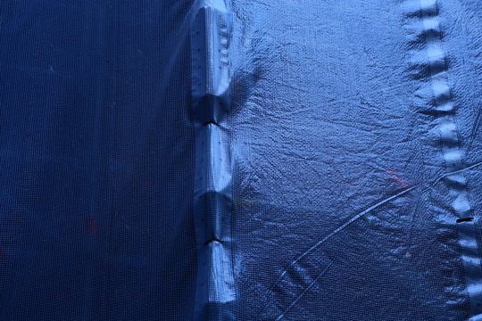 Construction work on old brick house with scaffolding, tarps, cement etc